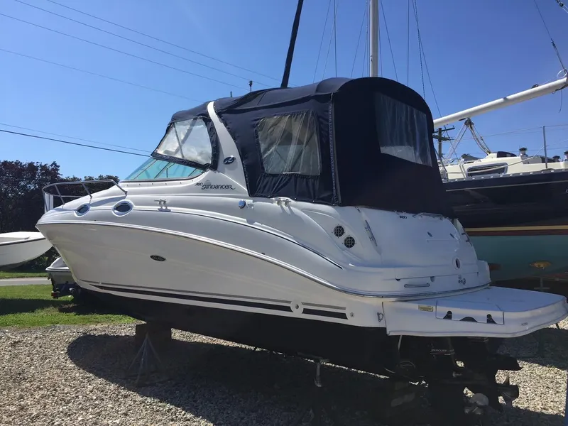 Slide: The Image of 2004 Sea Ray 280 Sundancer boat on dry dock with blue canopy. - 3