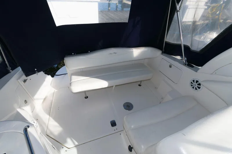 Slide: The Image of 2004 Sea Ray 280 Sundancer boat interior with white seating and dark blue canopy. - 6