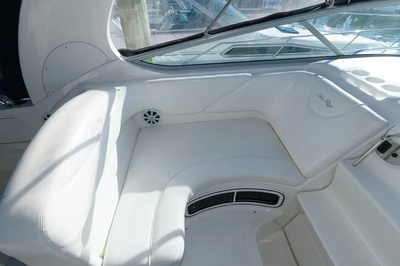 Slide: The Image of 2004 Sea Ray 280 Sundancer boat interior seating area with white upholstery. - 7