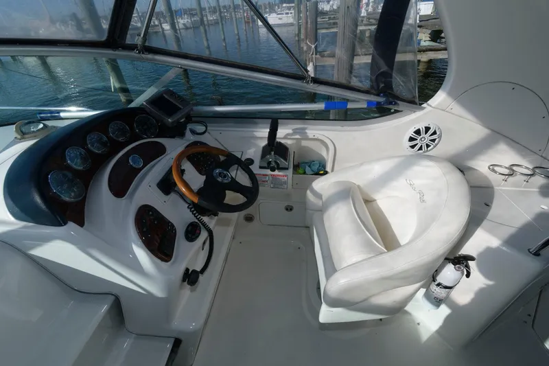 Slide: The Image of 2004 Sea Ray 280 Sundancer helm with steering wheel, gauges, and captain's chair. - 9