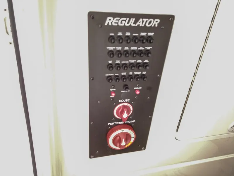 Slide: The Image of Control panel of a 2024 Regulator 28 boat with switches and dials. - 16