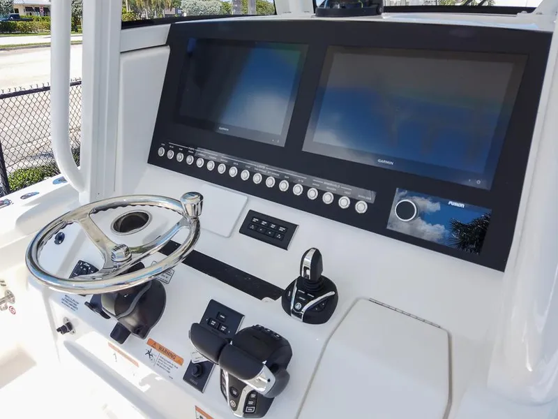 Slide: The Image of 2024 Regulator 28 boat dashboard with dual screens and steering wheel. - 2