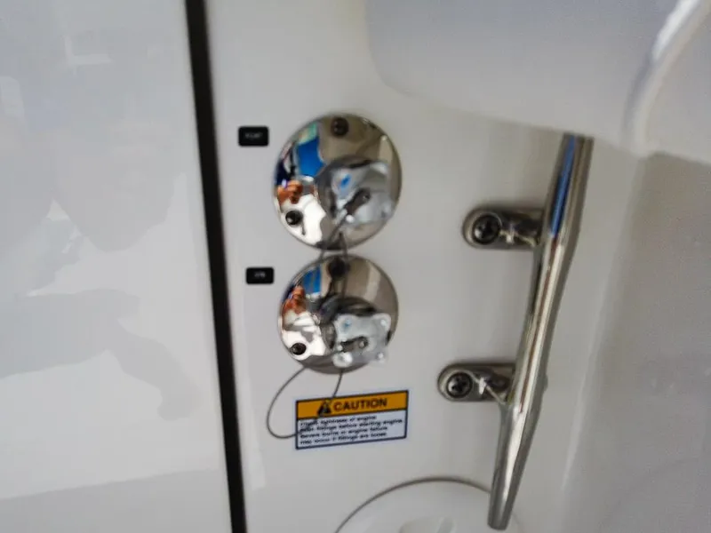 Slide: The Image of 2024 Regulator 28 boat fuel and water fill ports with caution label. - 20