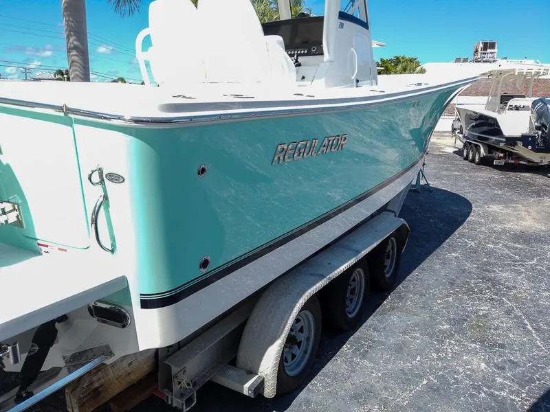 Slide: The Image of 2024 Regulator 28 boat on a trailer, side view with teal hull. - 25