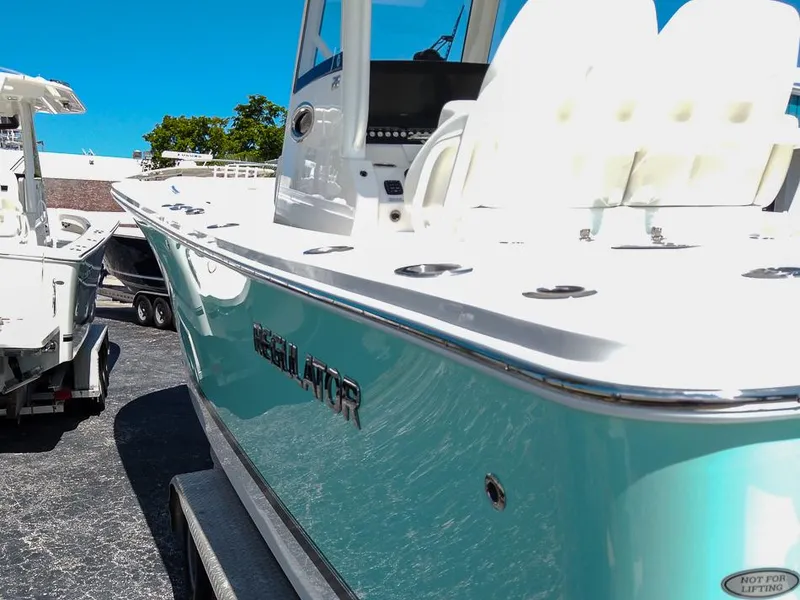 Slide: The Image of 2024 Regulator 28 boat with sleek design and white seating, parked on a trailer. - 26