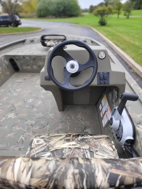 Slide: The Image of 2024 Tracker Grizzly 1754 SC boat interior with camo design and steering wheel. - 3
