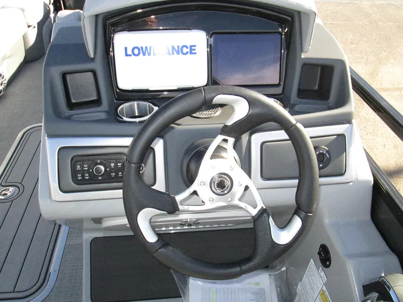 Slide: The Image of 2024 Regency 230 DL3 boat dashboard with Lowrance display and steering wheel. - 13