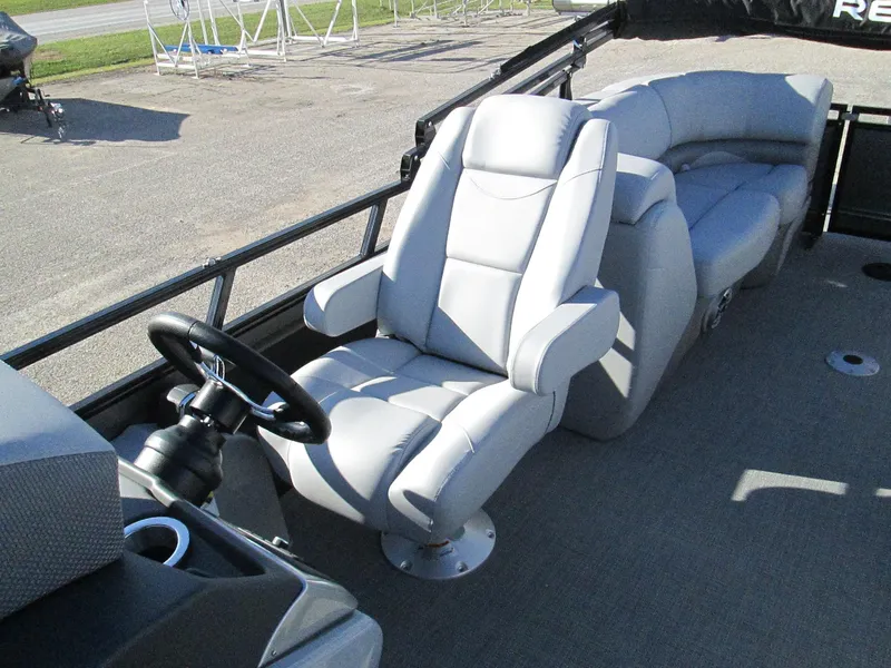 Slide: The Image of 2024 Regency 230 DL3 boat interior with plush seating and steering console. - 9