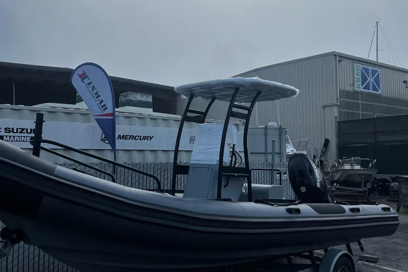 Slide: The Image of 2024 Inmar 670 Demo Boat displayed outdoors with a canopy and trailer. - 1