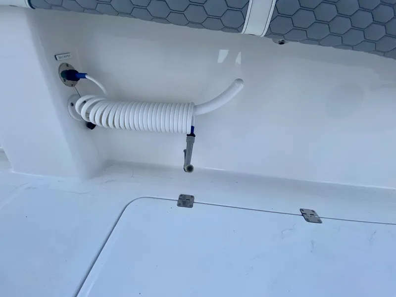 Slide: The Image of 2022 Invincible 35 Catamaran deck with coiled hose and storage compartment. - 24