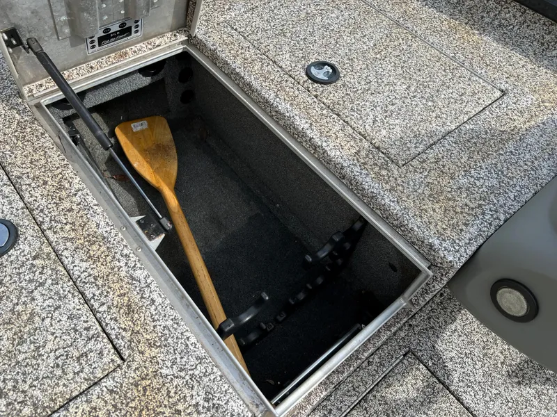 Slide: The Image of 2015 Tracker Pro Team 175 TXW storage compartment with a wooden paddle. - 13
