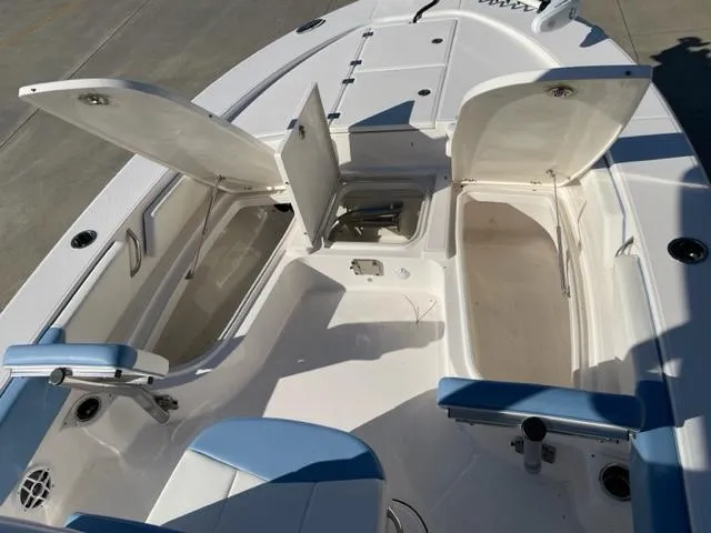 Slide: The Image of 2022 Robalo 246 Cayman boat with open storage compartments and seating. - 11