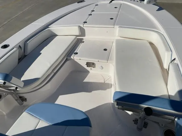 Slide: The Image of 2022 Robalo 246 Cayman boat interior with cushioned seating and storage compartments. - 14