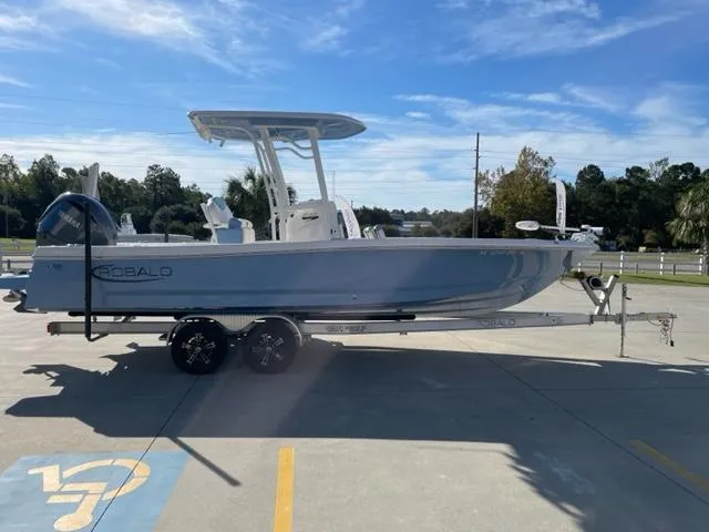 Slide: The Image of 2022 Robalo 246 Cayman boat on a trailer in a parking lot. - 2