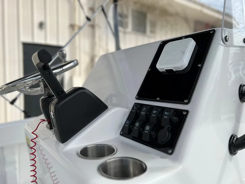 Slide: The Image of Clearwater 1900 2024 boat console with controls and cup holders. - 10