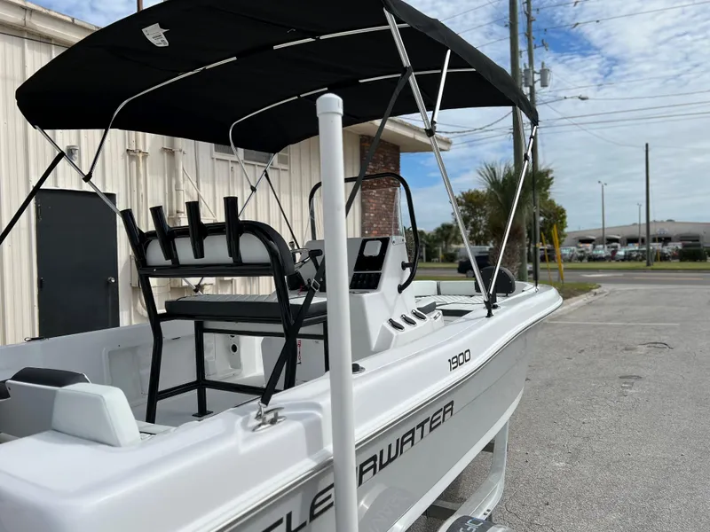Slide: The Image of 2024 Clearwater 1900 boat with black canopy, parked outdoors. - 25