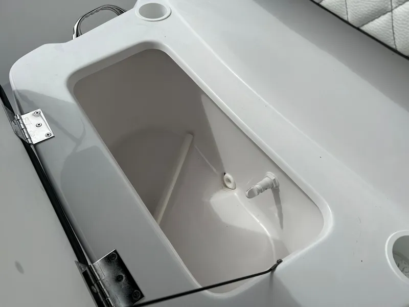 Slide: The Image of Clearwater 1900 2024 boat storage compartment with white interior and drain plug. - 27