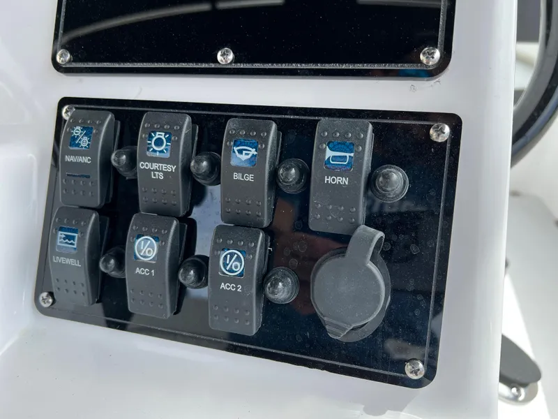 Slide: The Image of Control panel of a 2024 Clearwater 1900 boat with various switches. - 31