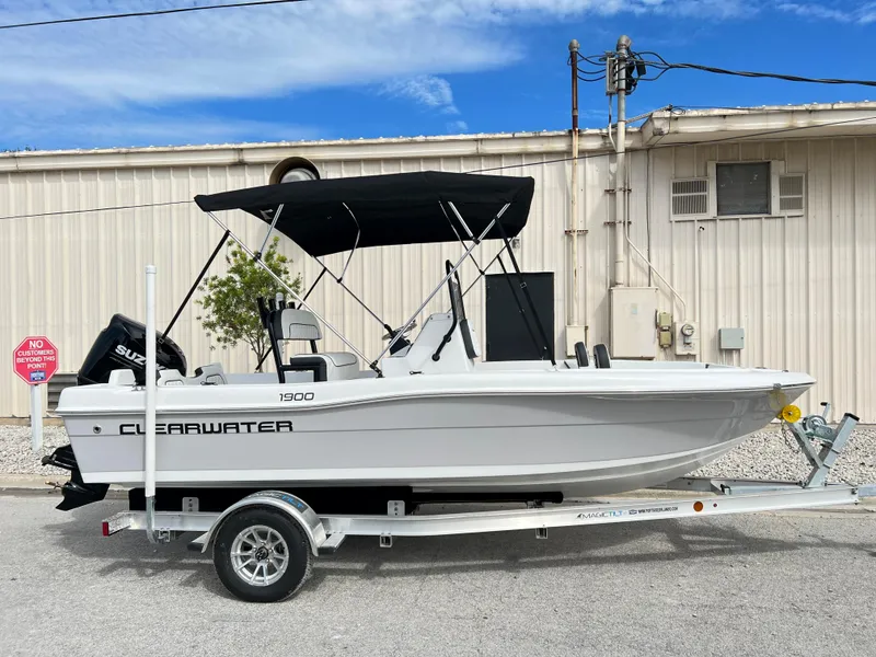 Slide: The Image of 2024 Clearwater 1900 boat on trailer with black canopy, parked outdoors. - 6
