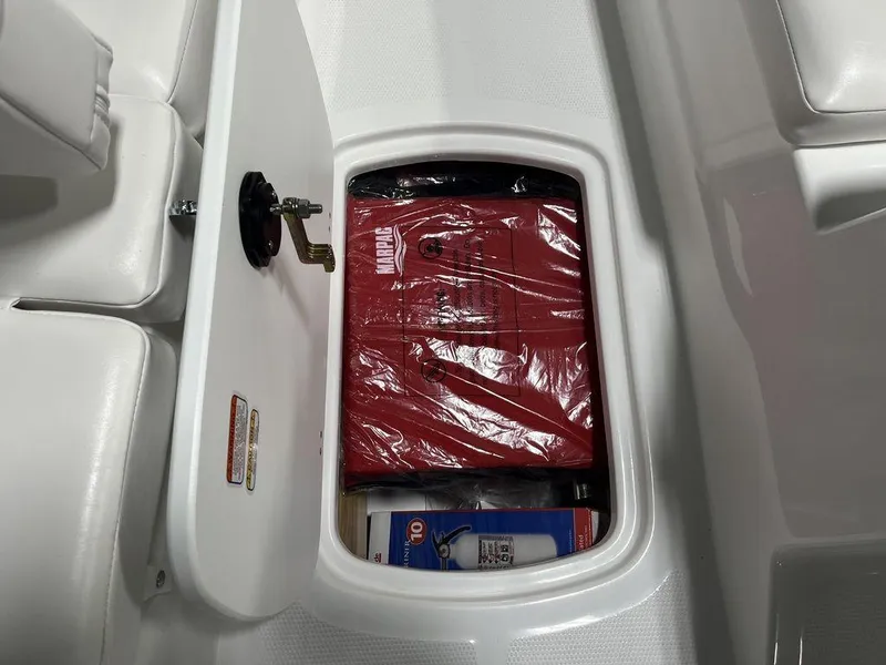 Slide: The Image of 2024 Tahoe T16 boat storage compartment with safety equipment and supplies. - 16