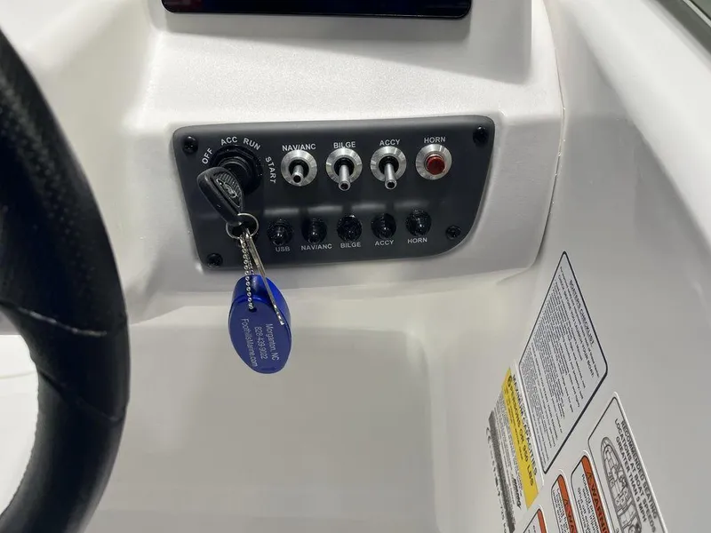 Slide: The Image of 2024 Tahoe T16 boat dashboard with ignition key and control switches. - 26