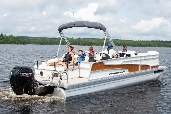 Slide: The Image of 2024 Princecraft Vectra 23 RL pontoon boat cruising on a lake with passengers. - 18