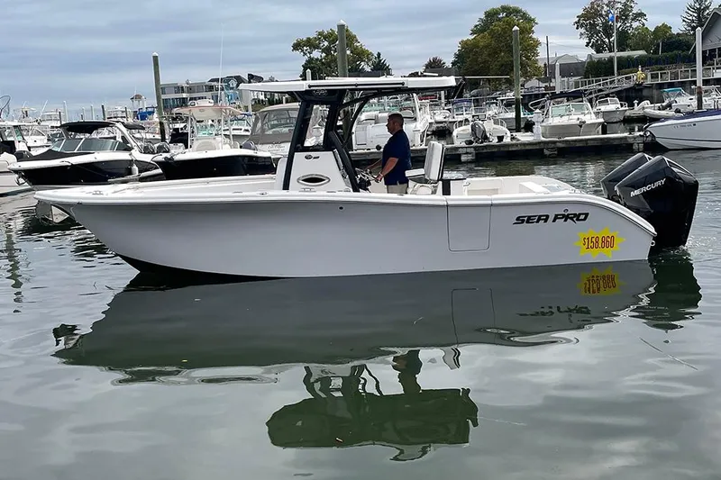 Slide: The Image of 2024 Sea Pro 262 DXL boat docked in marina, side view. - 1