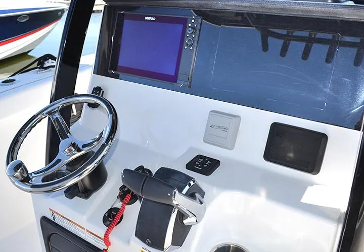 Slide: The Image of 2024 Sea Pro 262 DXL boat dashboard with steering wheel and navigation display. - 2