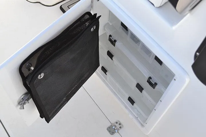 Slide: The Image of 2024 Sea Pro 262 DXL storage compartment with organized tackle boxes and mesh pouch. - 4