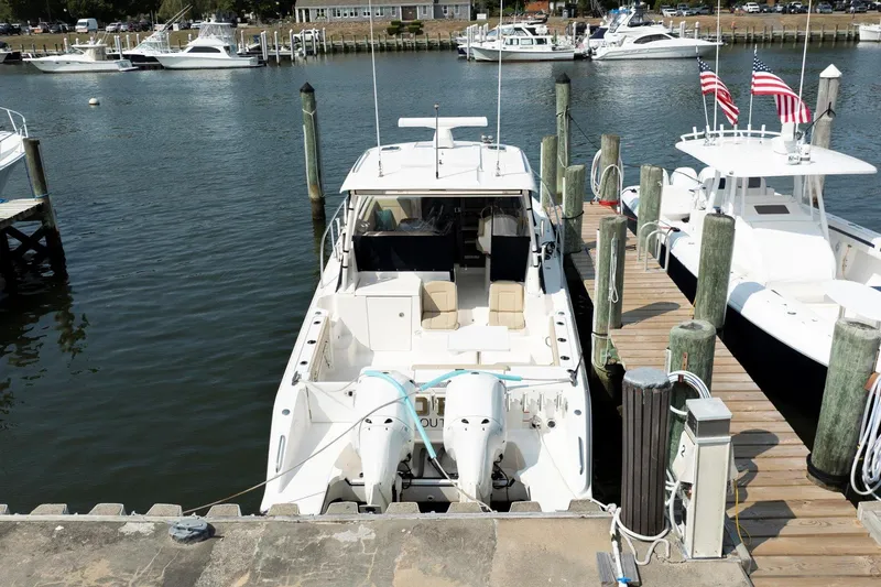 Slide: The Image of 2016 Pursuit OS 355 Offshore boat docked at marina with twin engines. - 11