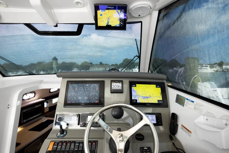 Slide: The Image of 2016 Pursuit OS 355 Offshore boat cockpit with navigation screens and steering wheel. - 17