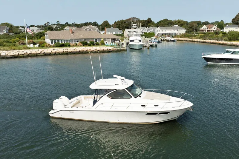 Slide: The Image of 2016 Pursuit OS 355 Offshore boat in a scenic marina setting. - 2