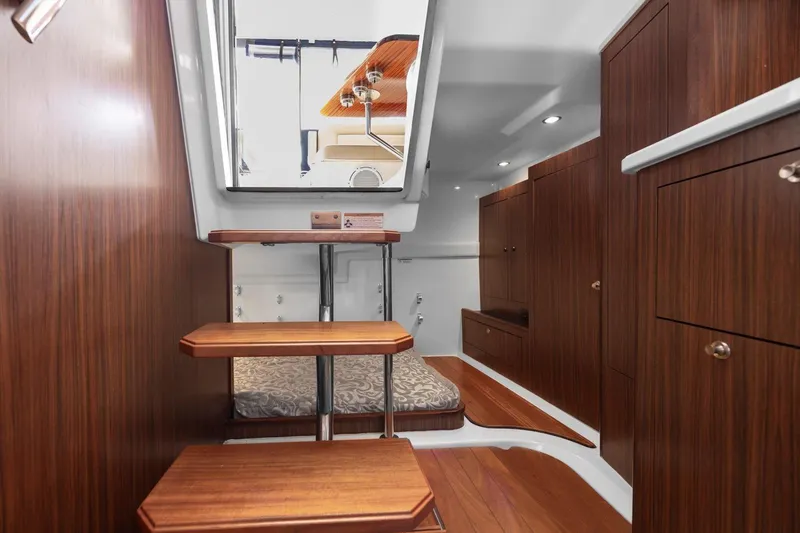 Slide: The Image of Interior of 2016 Pursuit OS 355 Offshore boat with wooden cabinetry and steps. - 21