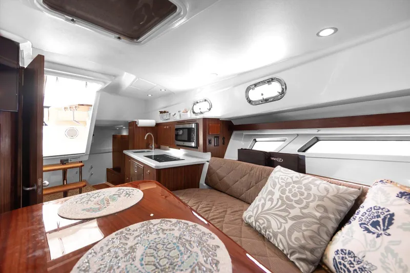 Slide: The Image of 2016 Pursuit OS 355 Offshore yacht interior with modern kitchen and cozy seating area. - 22