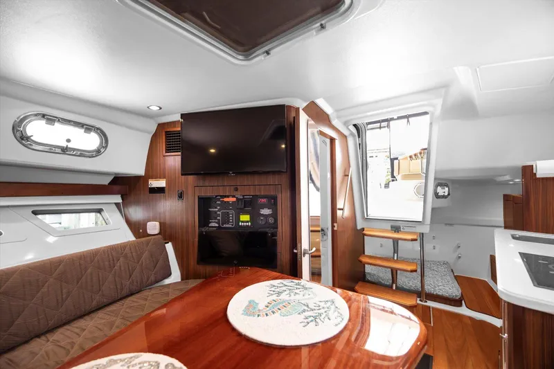 Slide: The Image of Interior of 2016 Pursuit OS 355 Offshore boat with modern amenities and wooden finishes. - 23