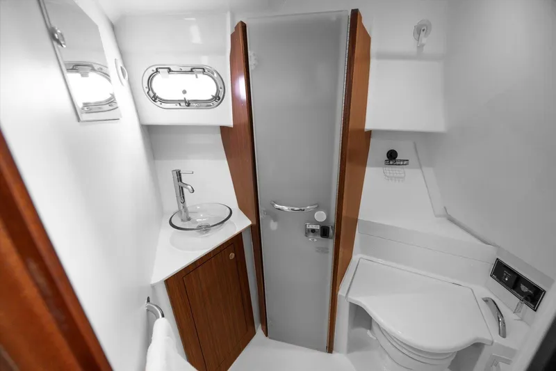 Slide: The Image of 2016 Pursuit OS 355 Offshore boat bathroom with modern fixtures and compact design. - 25
