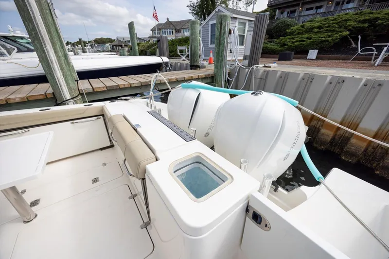 Slide: The Image of 2016 Pursuit OS 355 Offshore boat docked, showcasing deck and outboard engines. - 27