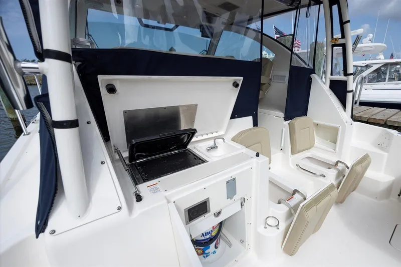 Slide: The Image of 2016 Pursuit OS 355 Offshore boat interior with seating and grill. - 28