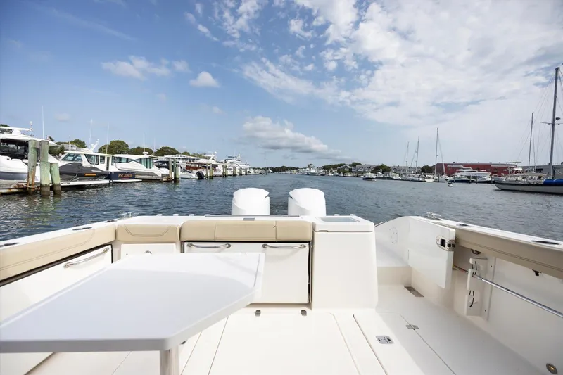 Slide: The Image of 2016 Pursuit OS 355 Offshore boat docked in a marina, clear sky, calm water. - 31