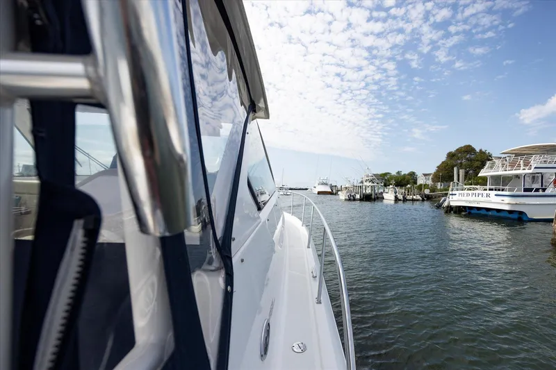Slide: The Image of 2016 Pursuit OS 355 Offshore boat docked in a scenic marina. - 32