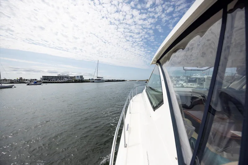 Slide: The Image of 2016 Pursuit OS 355 Offshore cruising in a marina under a partly cloudy sky. - 33