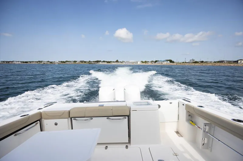 Slide: The Image of 2016 Pursuit OS 355 Offshore boat cruising on open water, leaving a wake behind. - 35