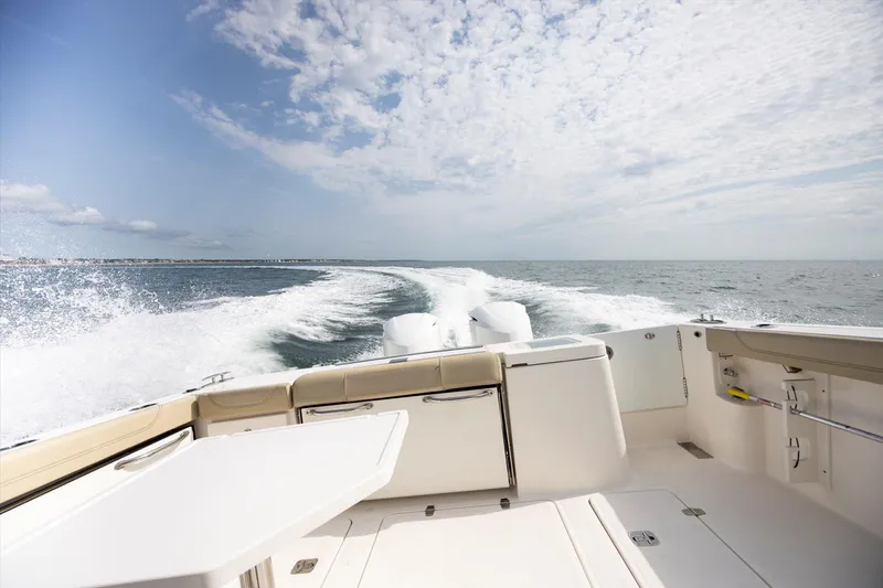 Slide: The Image of 2016 Pursuit OS 355 Offshore cruising on open water under a clear sky. - 36