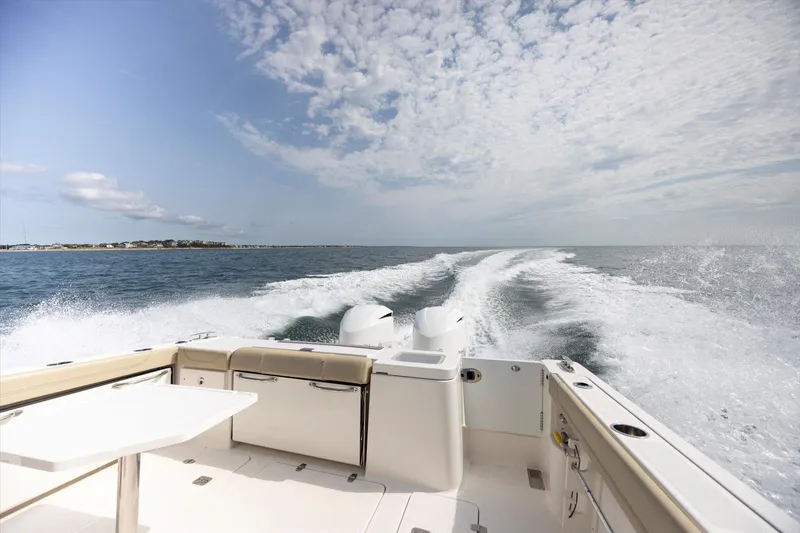 Slide: The Image of 2016 Pursuit OS 355 Offshore boat cruising on open water under a cloudy sky. - 37