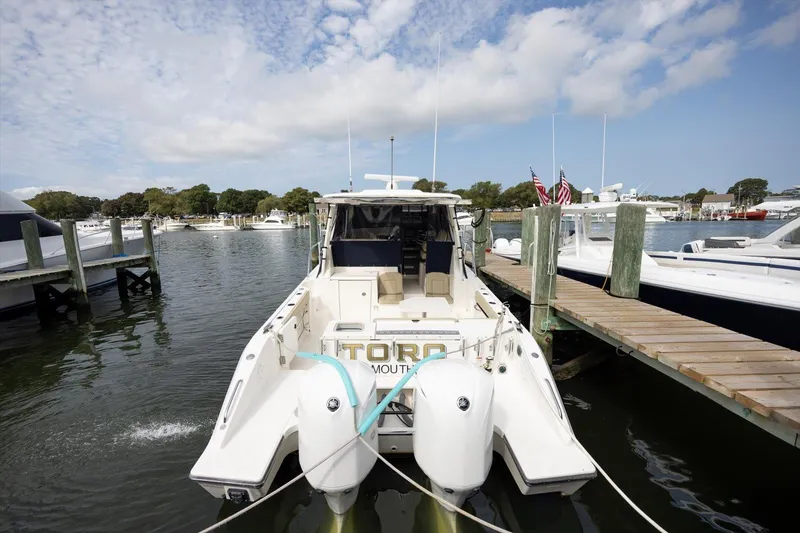 Slide: The Image of 2016 Pursuit OS 355 Offshore boat docked in a marina, rear view. - 5