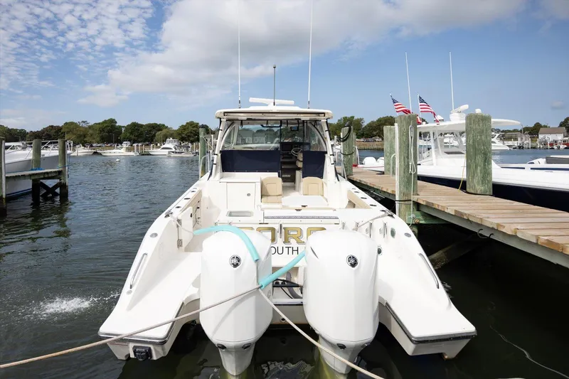 Slide: The Image of 2016 Pursuit OS 355 Offshore boat docked at marina with twin engines. - 8