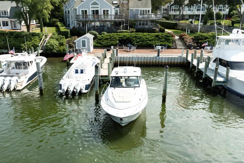 Slide: The Image of 2016 Pursuit OS 355 Offshore docked at a marina with waterfront homes. - 9