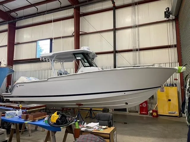 Slide: The Image of 2023 Bertram 28 CC boat in a warehouse, side view. - 4