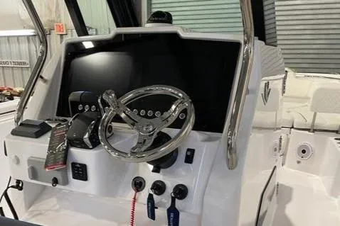 Slide: The Image of 2023 Bertram 28 CC boat dashboard with steering wheel and control panel. - 5