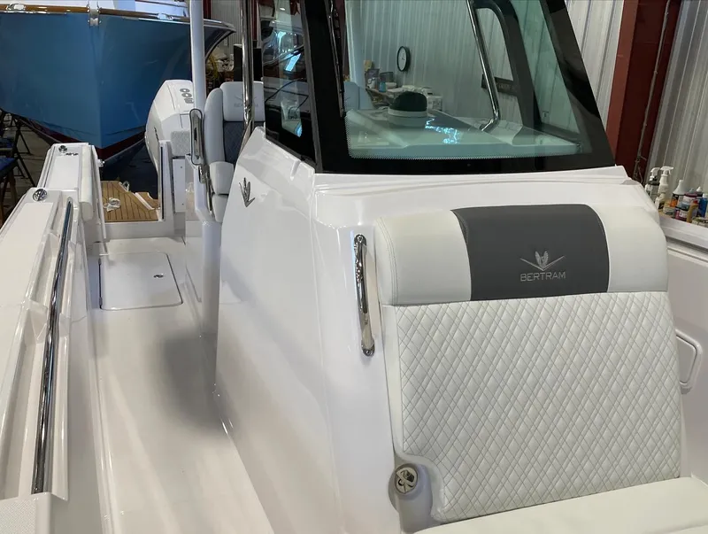 Slide: The Image of 2023 Bertram 28 CC boat interior with white seating and console. - 8